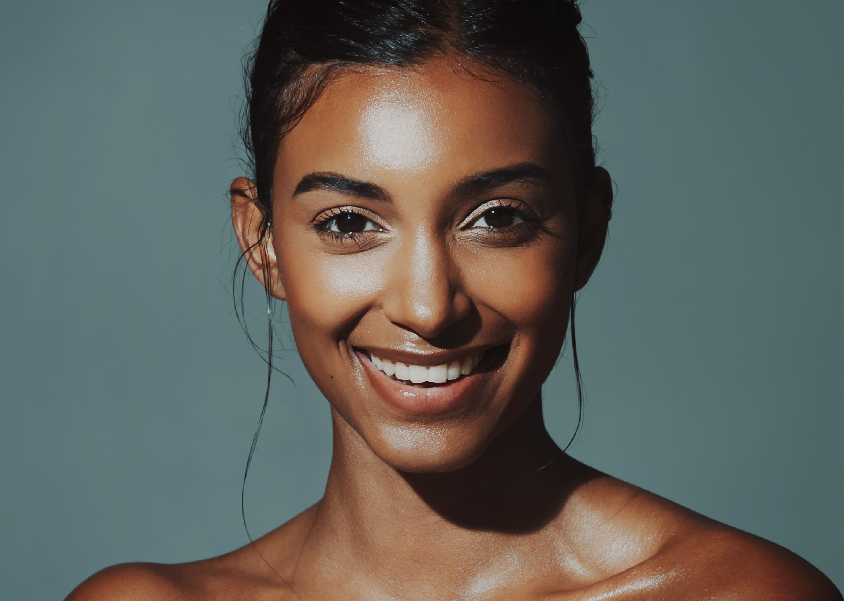 Close portrait of a smiling woman with her hair pulled back